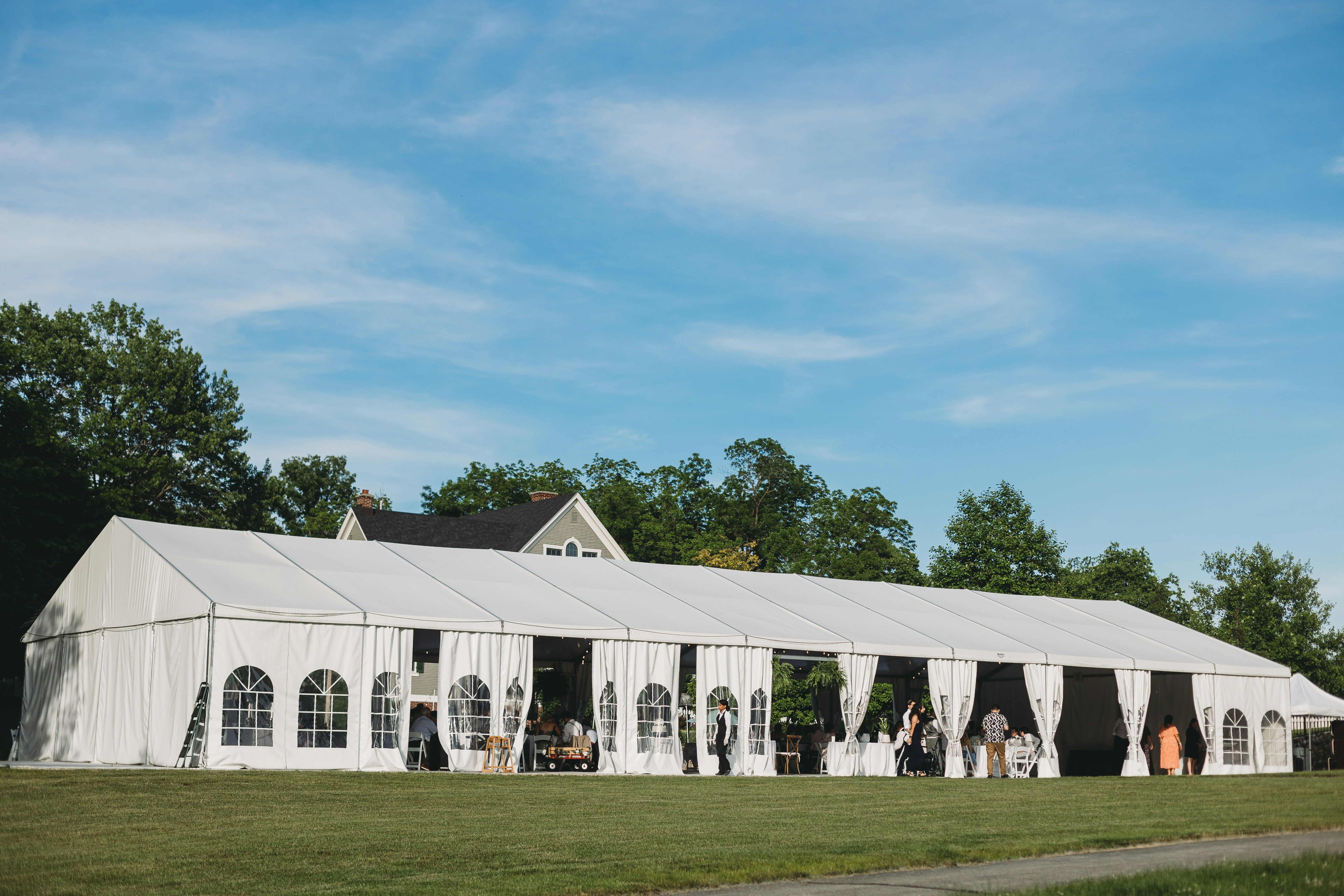Beautifully dressed premium event tent rental setup inside with draped interior and pristine arrangements